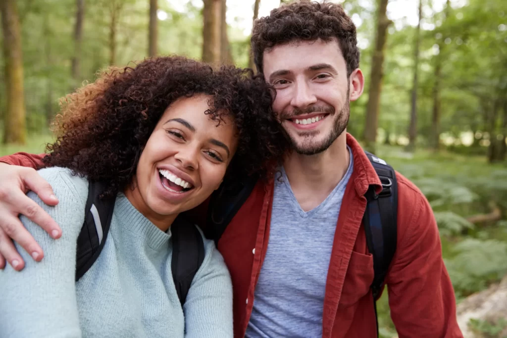 a young adult mixed race couple laughing to camera utc