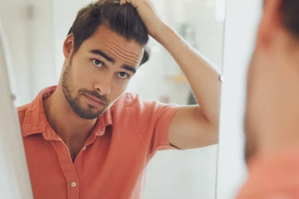 handsome young caucasian man touching his hair and utc