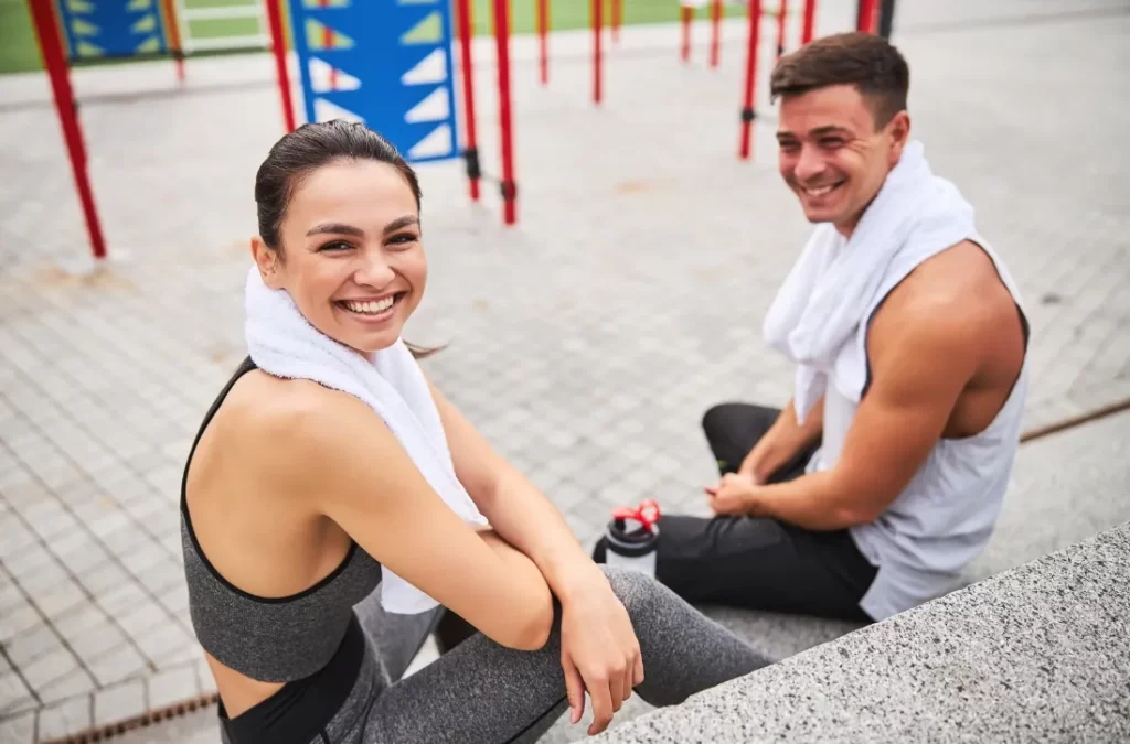 happy young couple relaxing after workout on sport utc