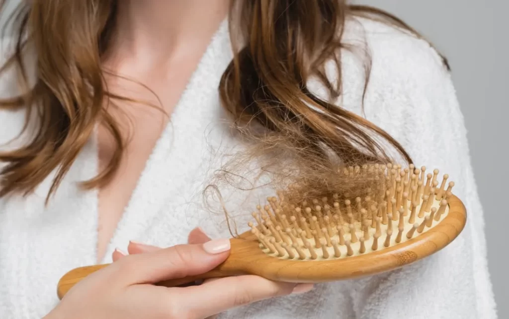 partial view of young woman holding wooden hair br utc